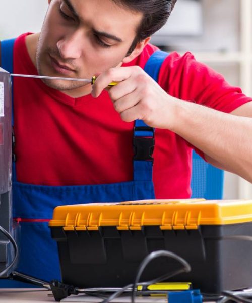 Professional repair engineer repairing broken tv